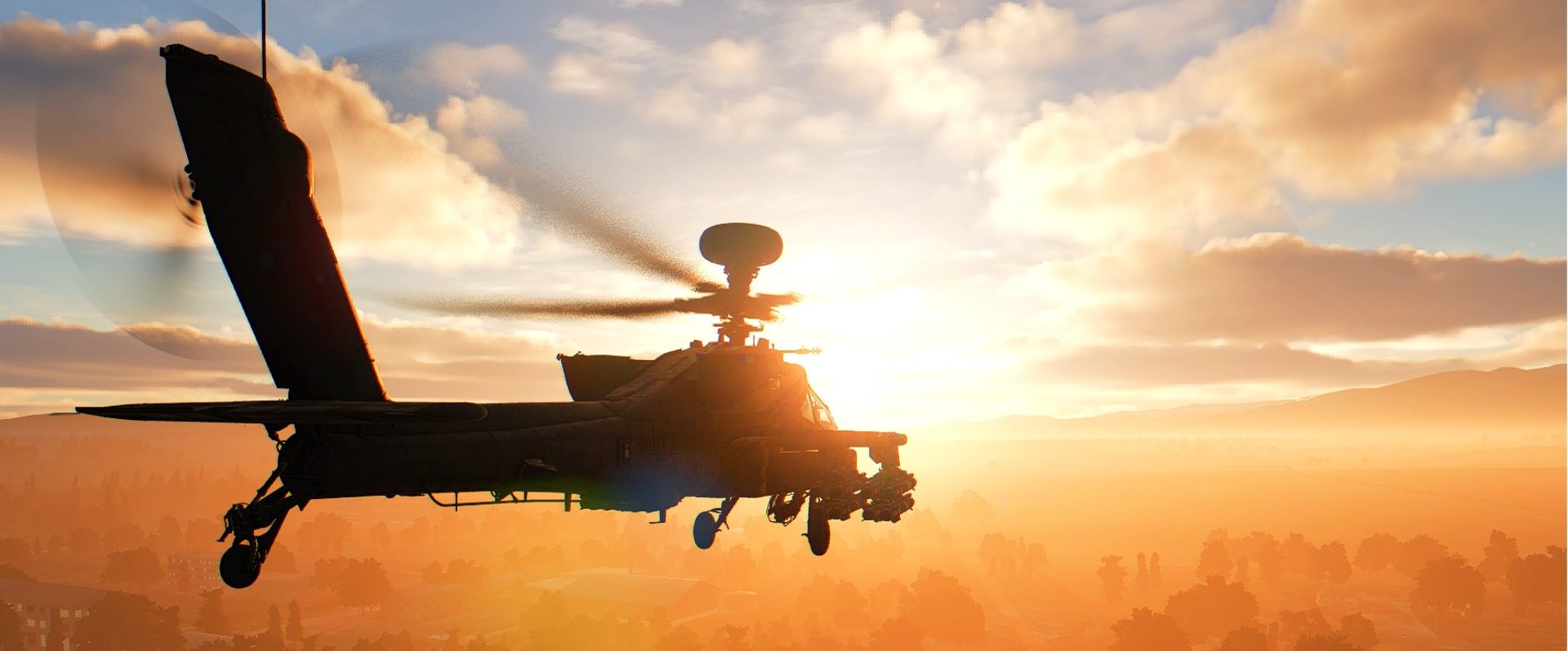 An AH-64D Apache silhouetted against a sunset
