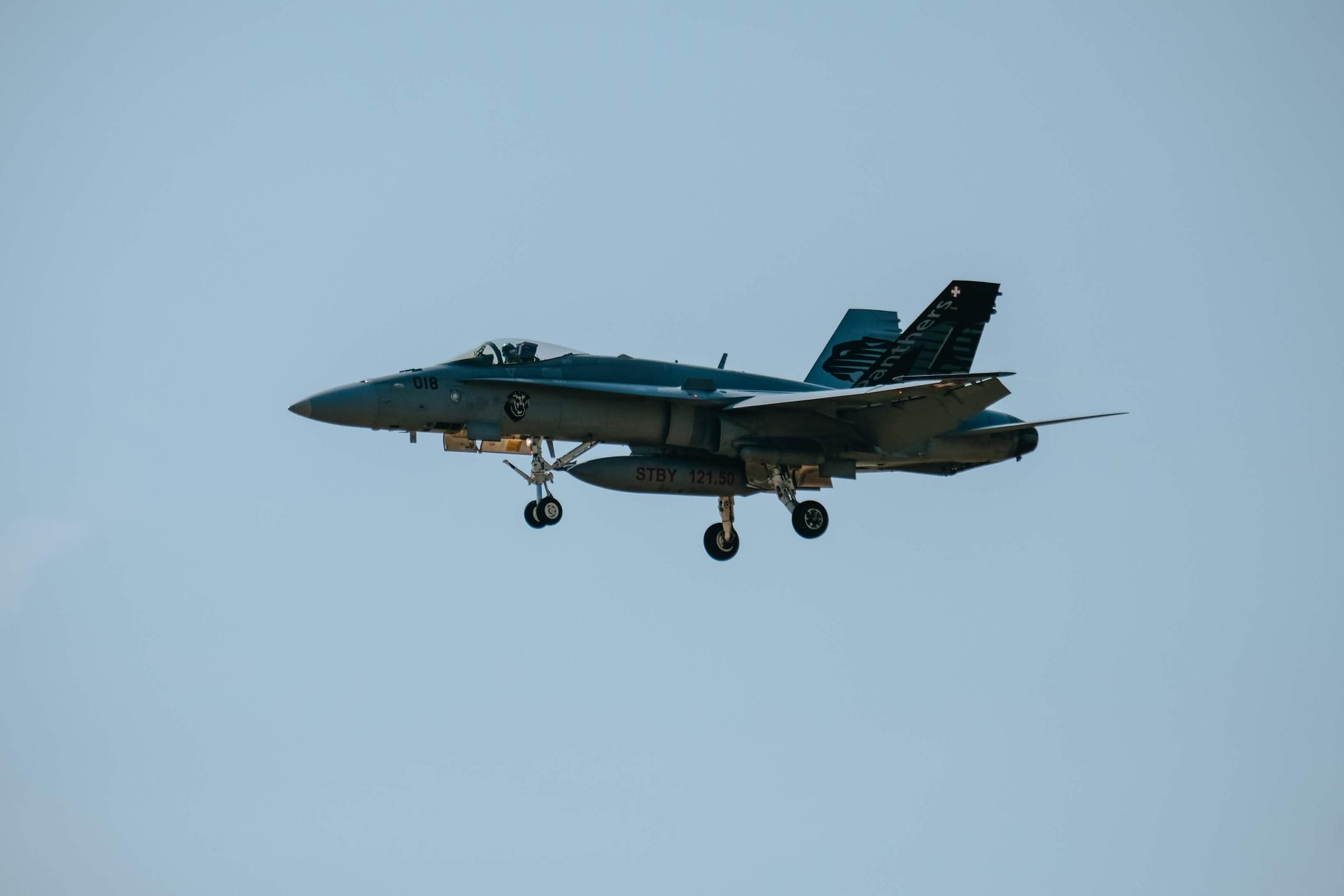 An F/A-18C Hornet with gear down on approach