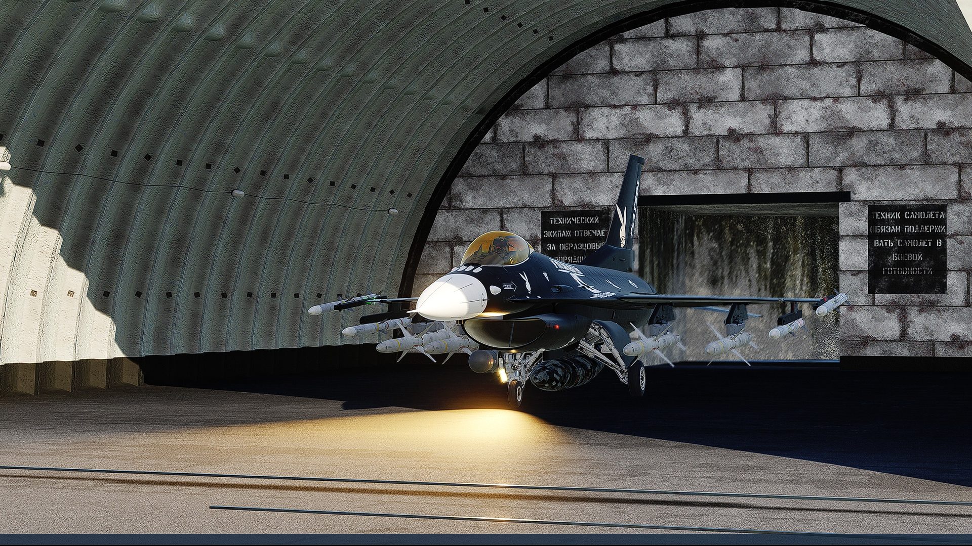An F-16C inside a hardened shelter with its lights on