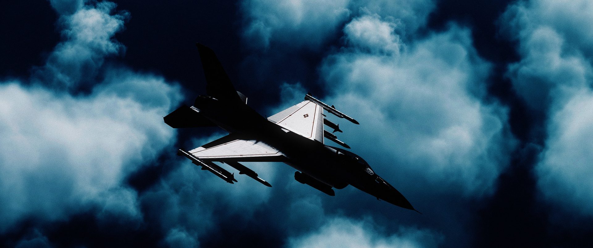 An F-16C rolling through storm clouds with missiles on the rails